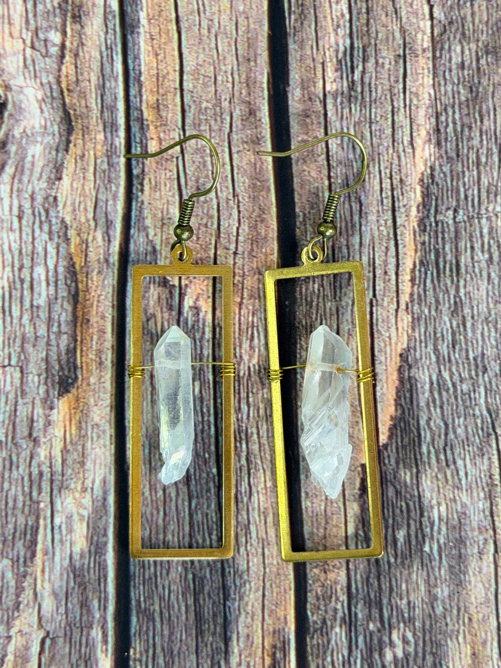 Angel Aura crystal frame earrings on a neutral surface