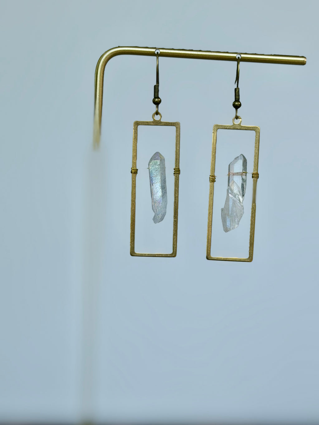 Celestial Window Angel Aura Earrings displayed on a gold jewelry stand
