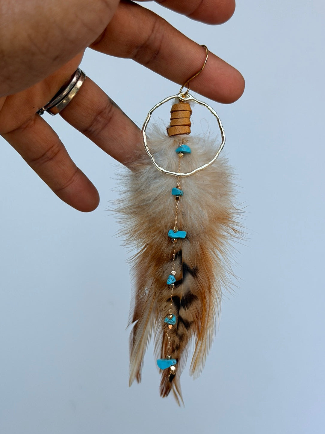 Desert Sky Feather Hoop Earring held by hand to show its size and details
