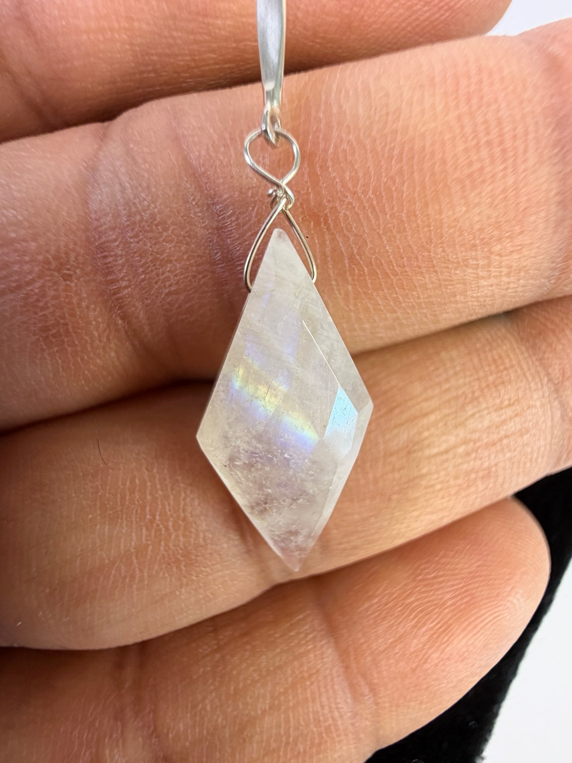 Close-up of the faceted diamond-shaped rainbow moonstone drop