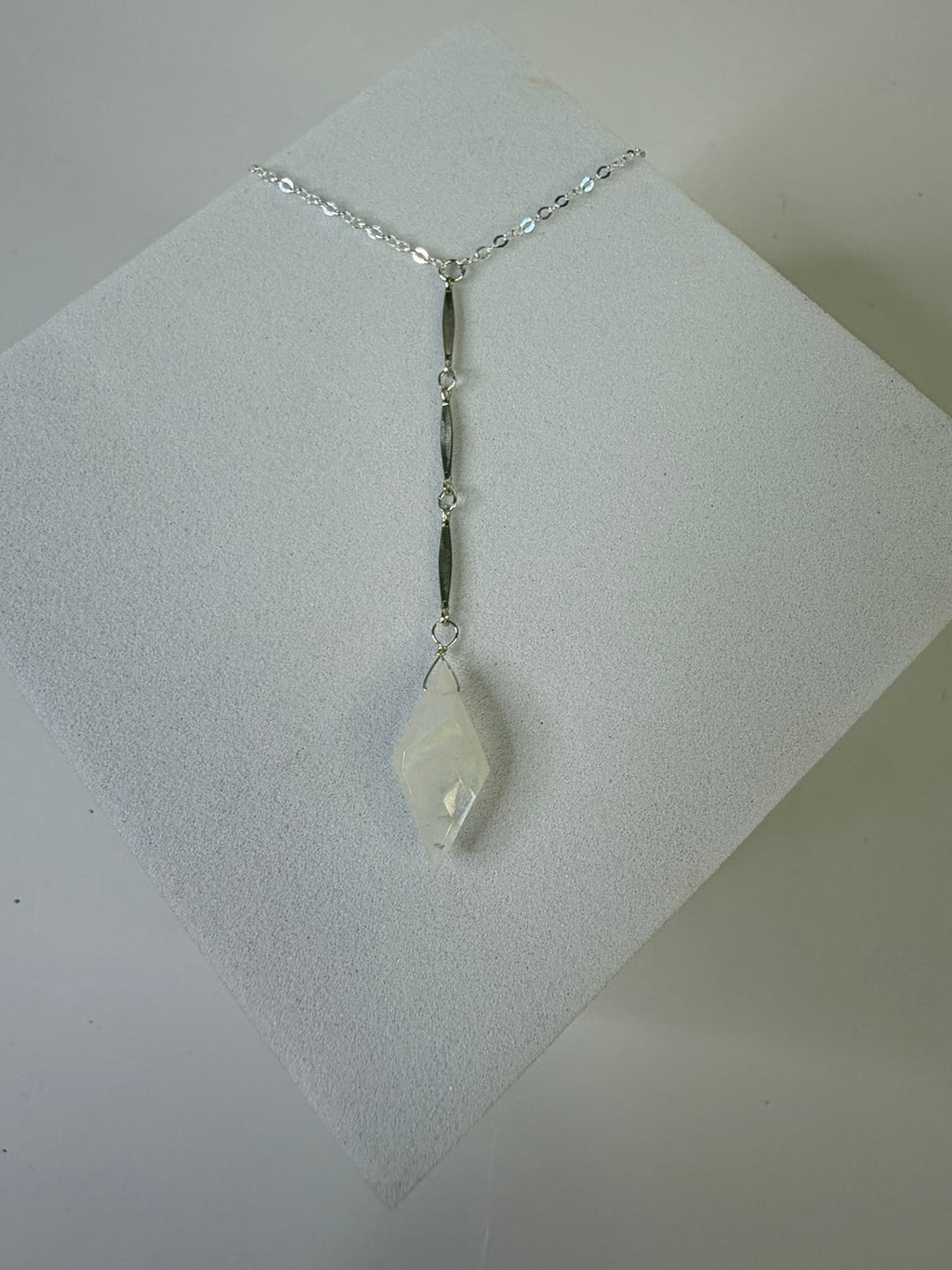 Sterling silver Goddess Light Rainbow Moonstone Y Necklace displayed on a neutral stand