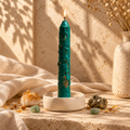 Handcrafted green prosperity ritual candle with citrine, pyrite, and green aventurine in golden sunlight