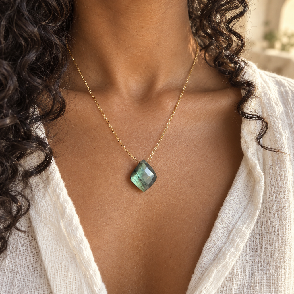 Labradorite Petal Necklace on a brown-skinned model wearing an ivory blouse