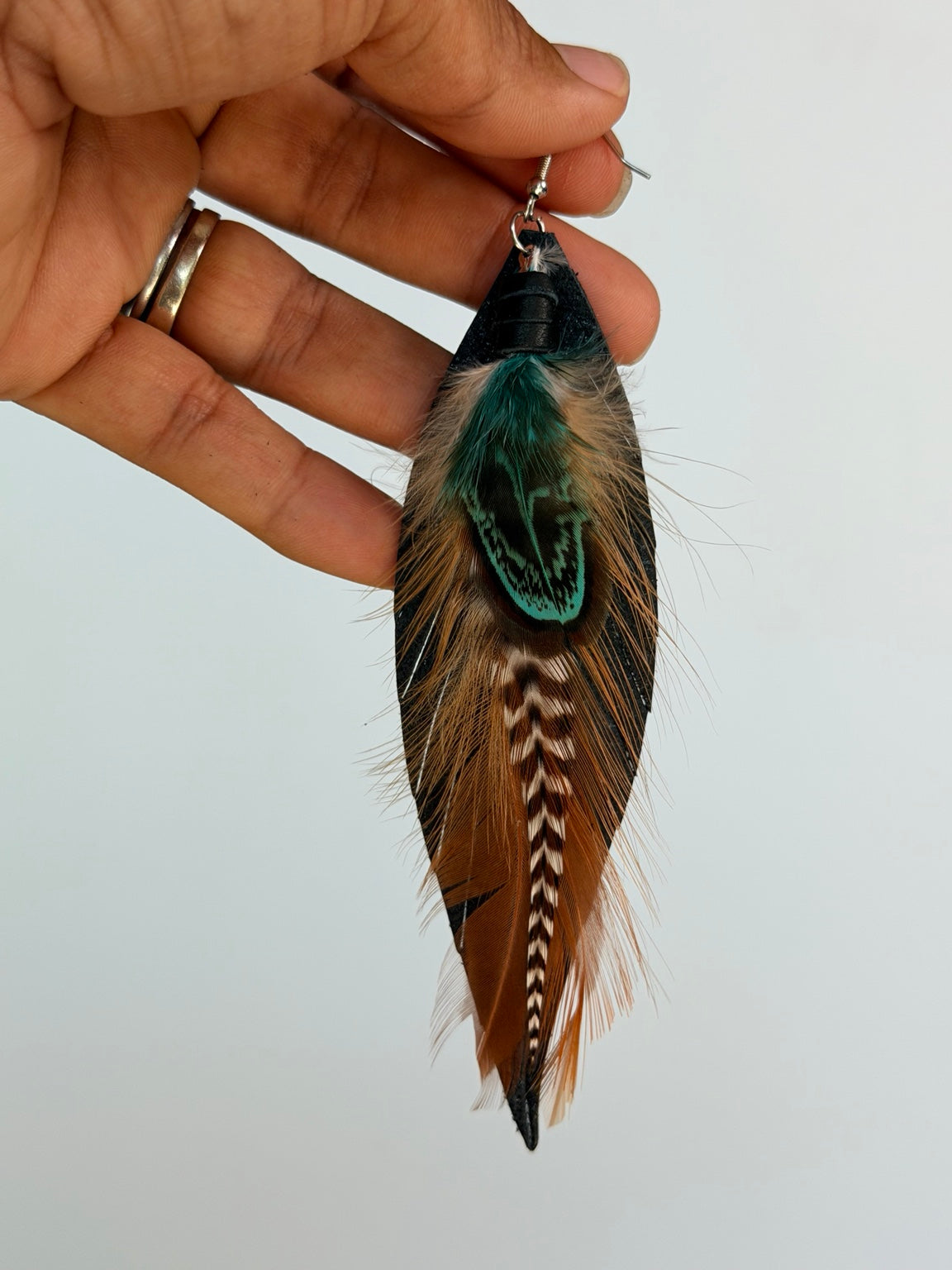 Actual Sagefire Feather Earring held by Karina for scale